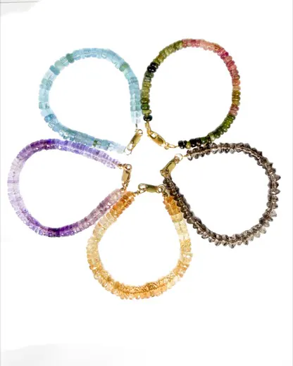 Five faceted bead bracelets arranged in a flower — aquamarine, tourmaline, amethyst, citrine and smoky quartz